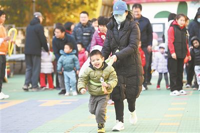 在北京市東城區(qū)欣苑幼兒園舉辦的“冬日暖陽 樂享運動”親子運動會上，家長陪伴孩子共同體驗運動的快樂，家校聯(lián)手呵護孩子健康成長。 新華社記者 金良快攝