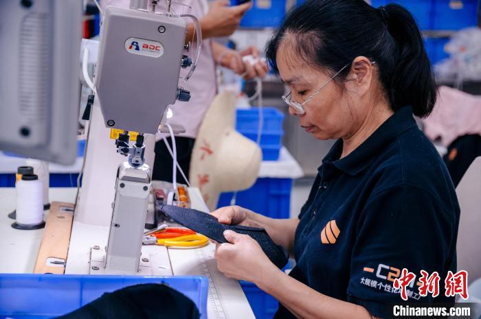 圖為員工在生產(chǎn)線工作?！±钅宪?攝