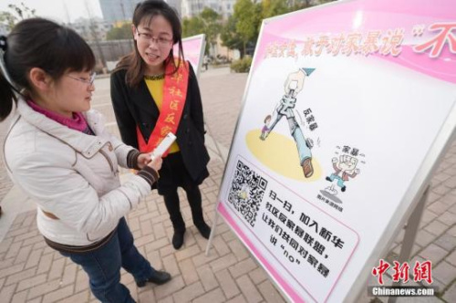 資料圖：今年3月8日，安徽合肥新華社區(qū)志愿者夏一瓊(右)向市民普及反家暴相關(guān)法律知識。鐘欣 攝